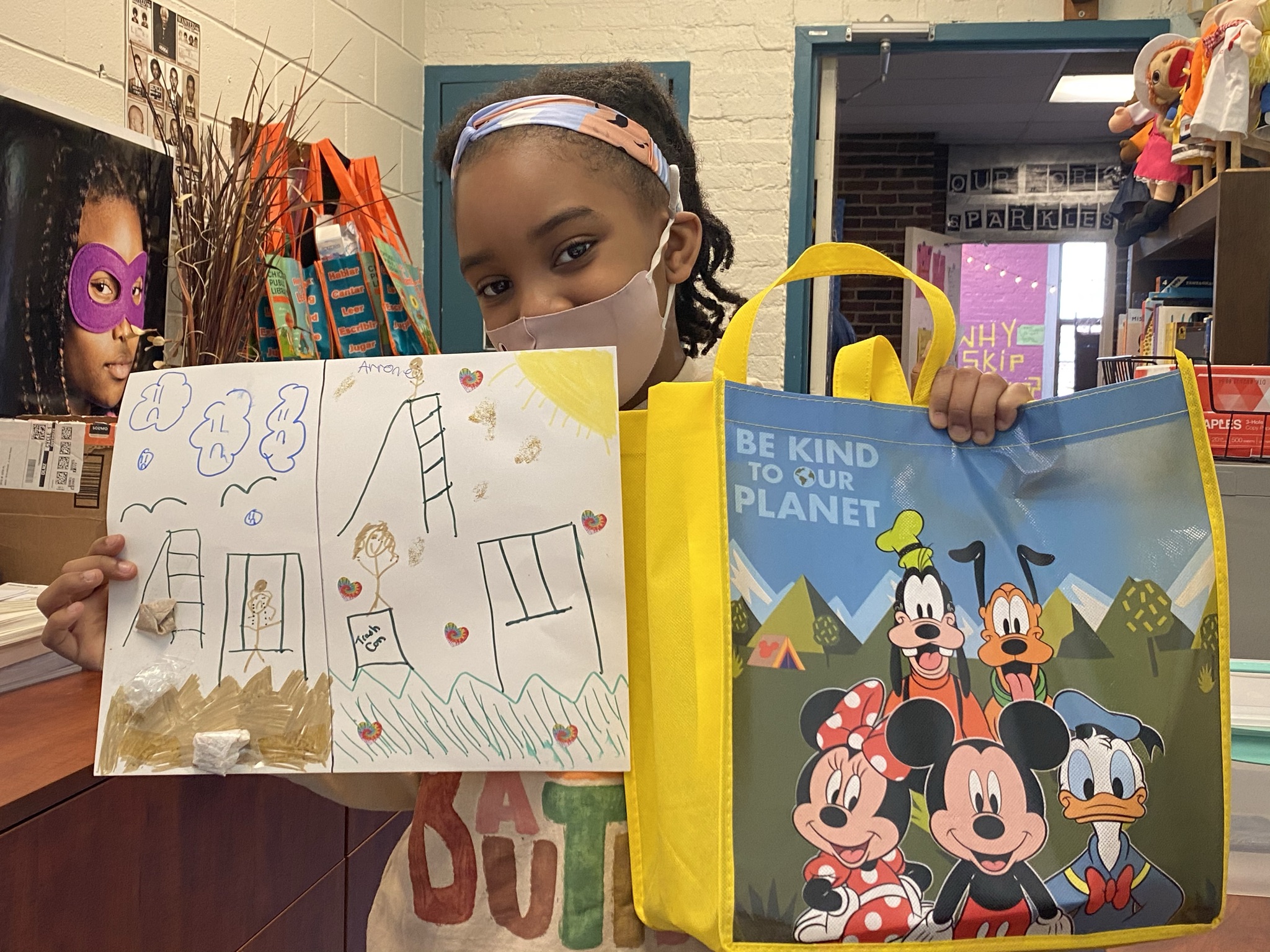 A student holds up Earth Day posters