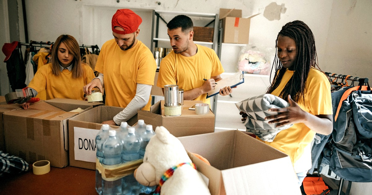 Group of people packing food distribution boxes and socializing