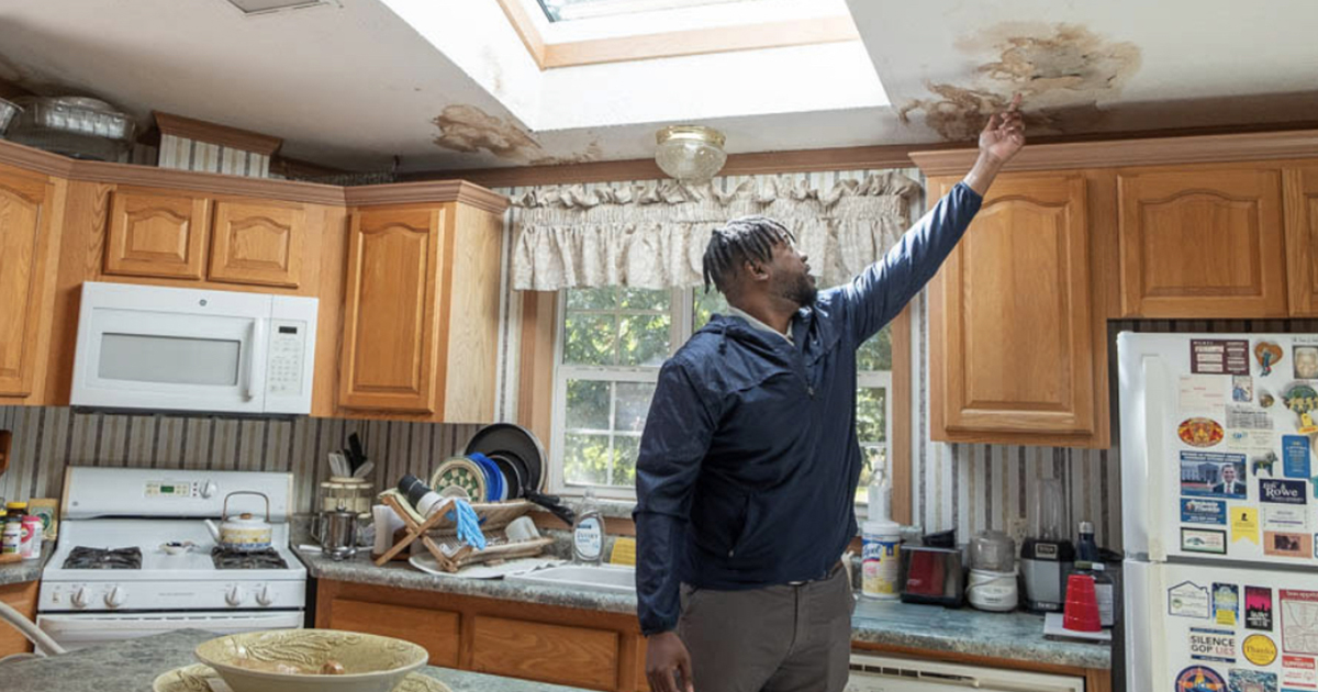 Lee Ringo points out damage caused by a leaking skylight