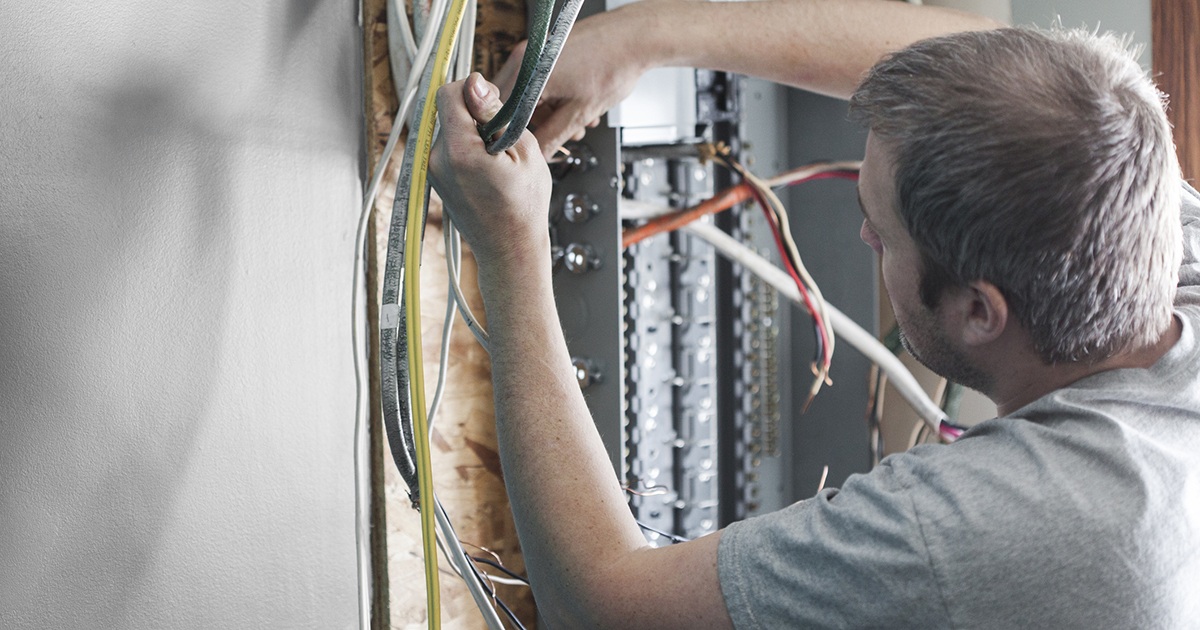 An electrician working on a panel