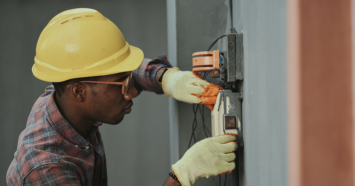 A worker examining electrical equipment
