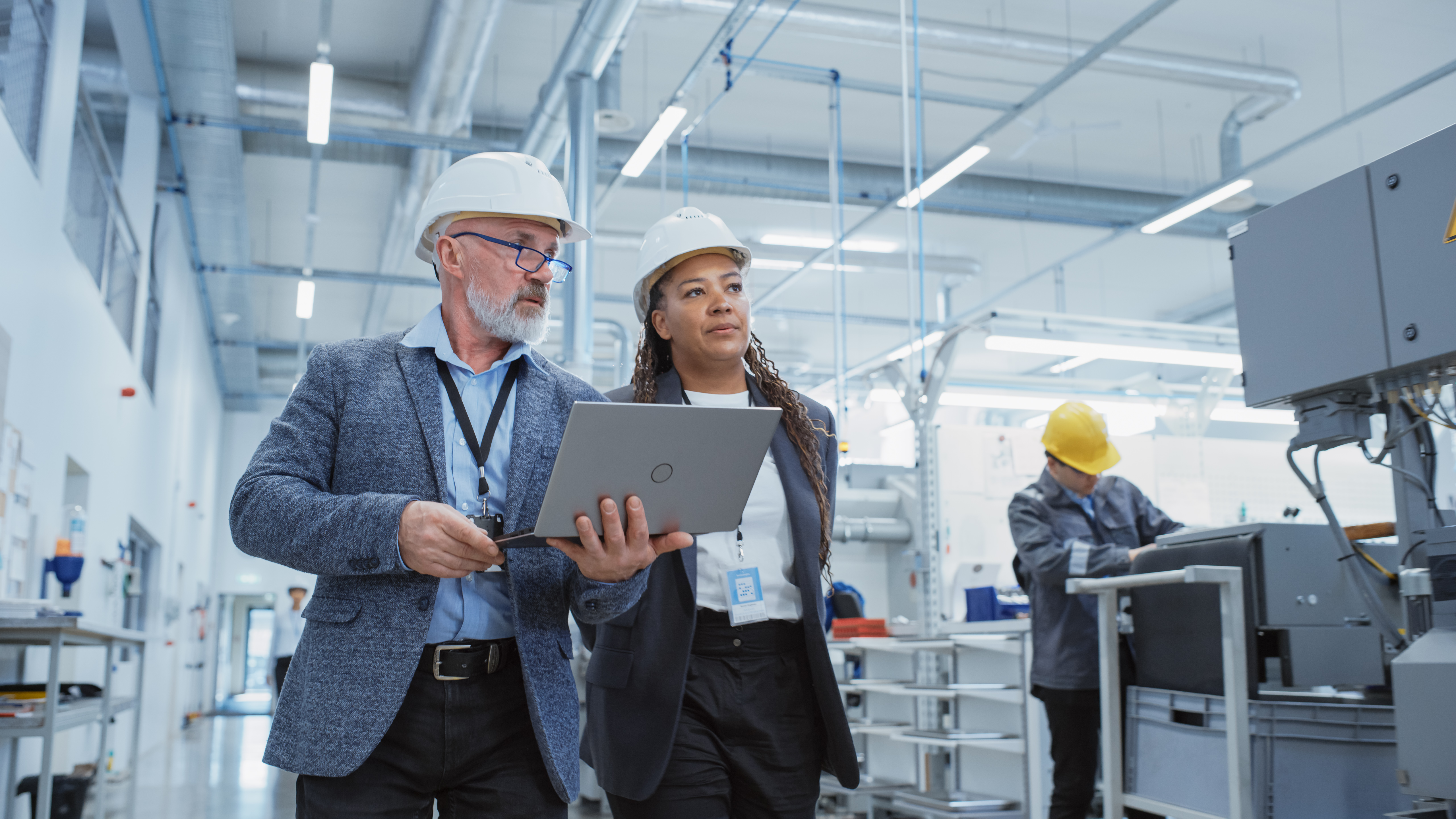 Employees in hard hats at manufacturing facility.