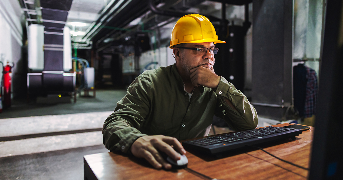 An engineer looking at a computer in a building control room